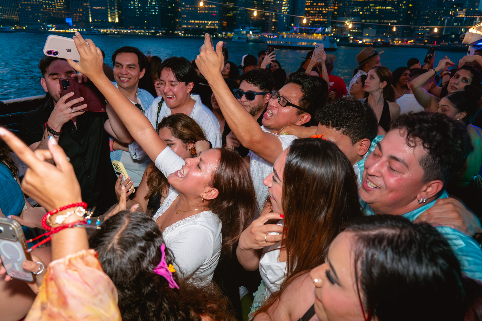A packed Drink Up NYC yacht party dancing under the Manhattan skyline